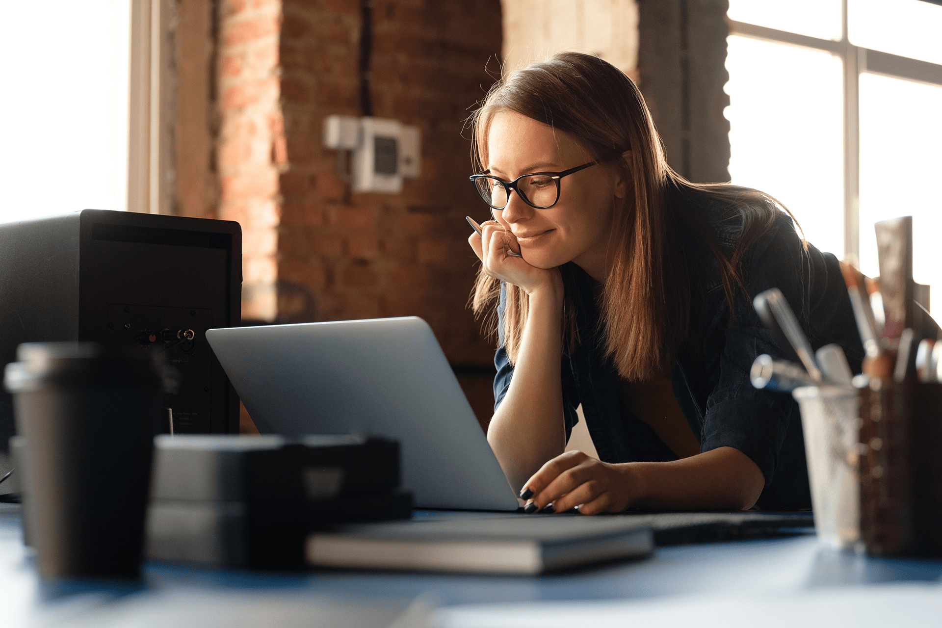 a woman working from home looks down at her laptop